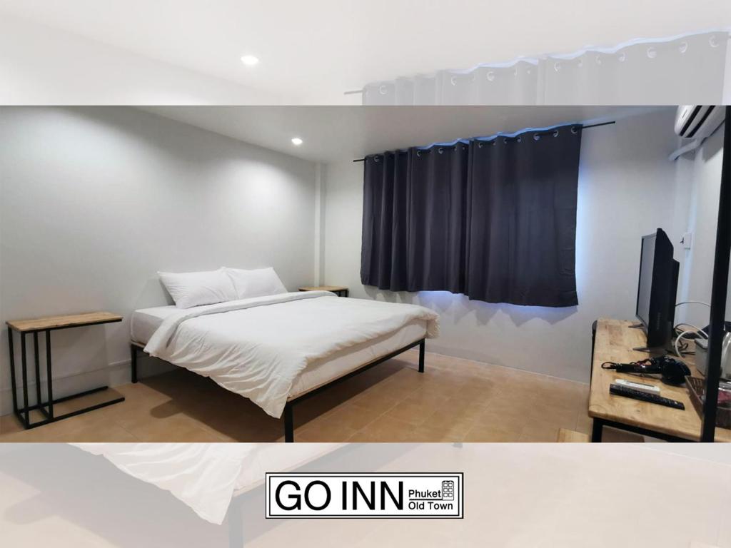 a bedroom with a bed and a tv in a room at Go Inn Phuket old Town in Phuket Town