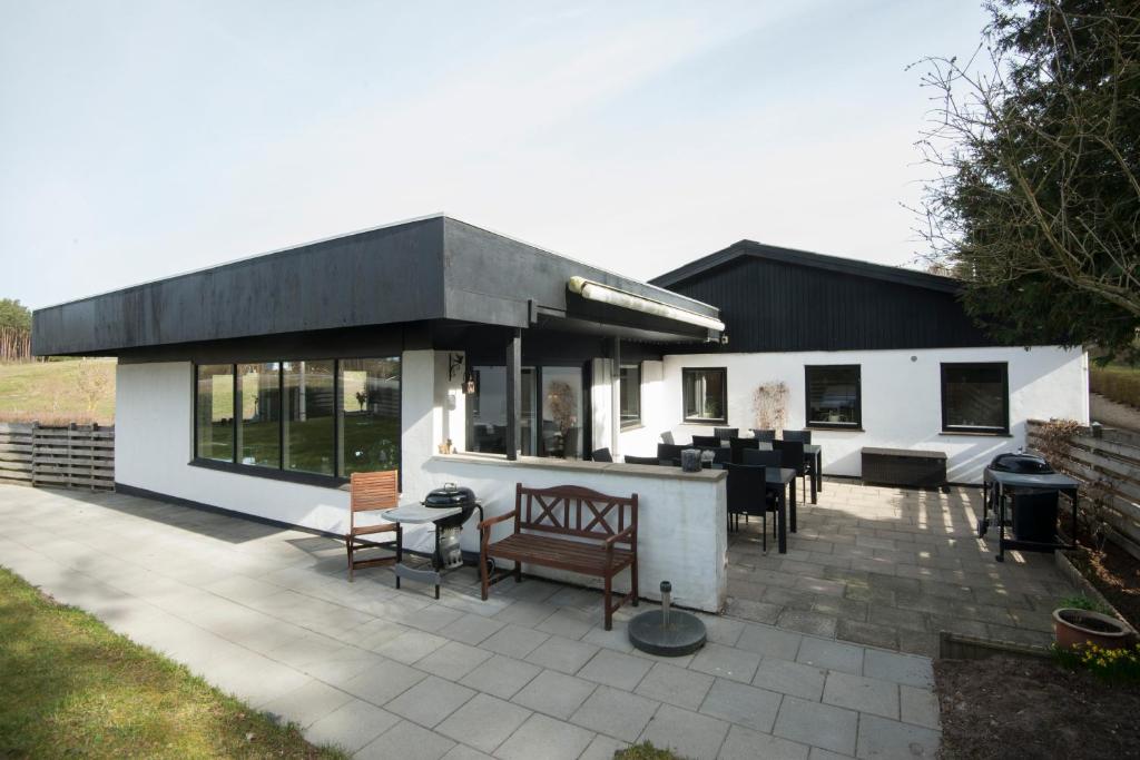 ein Haus mit einer Terrasse mit Tischen und Stühlen in der Unterkunft Ebeltoft Feriecenter in Ebeltoft