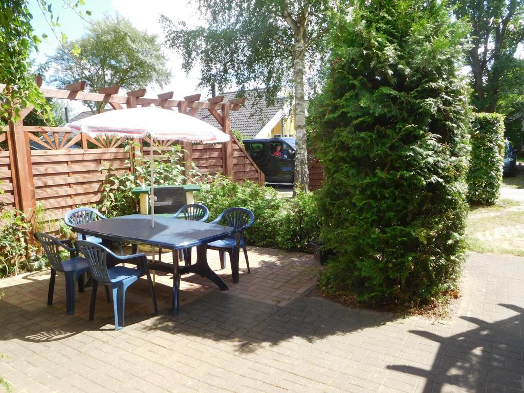 a table and chairs in a garden with a tree at -Waldhaus-Fewo 3 in Mirow