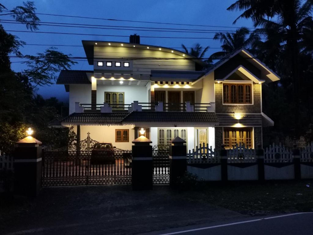 a white house with lights on it at night at Rose Cottage in Munnar