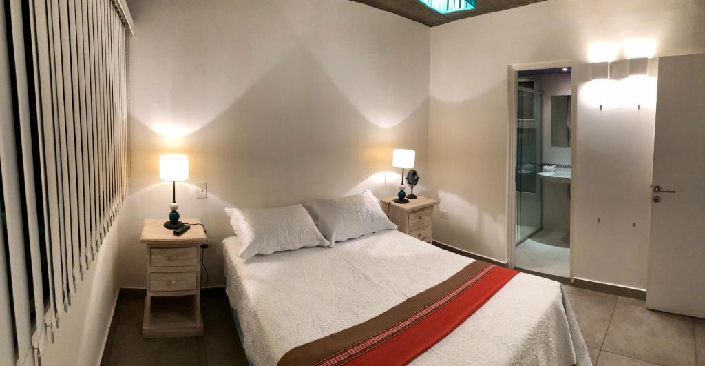 een slaapkamer met een bed en twee lampen op twee tafels bij Departamento - Edificio Los Naranjos in San Salvador de Jujuy