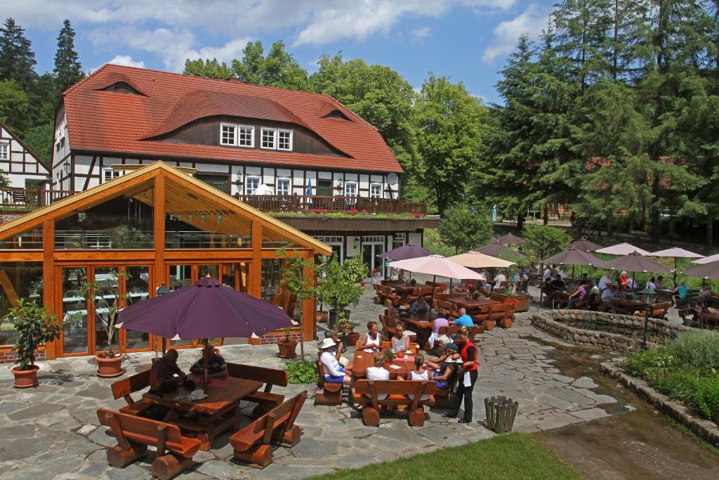 a group of people sitting at tables in front of a building at Hotel Boltenmühle in Gühlen Glienicke