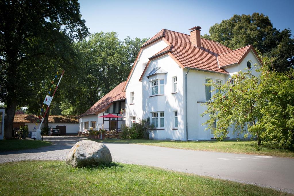 Uma casa branca com uma pedra à frente. em Komfort-Ferienwohnungen"Am Furlbach" em Schloß Holte-Stukenbrock