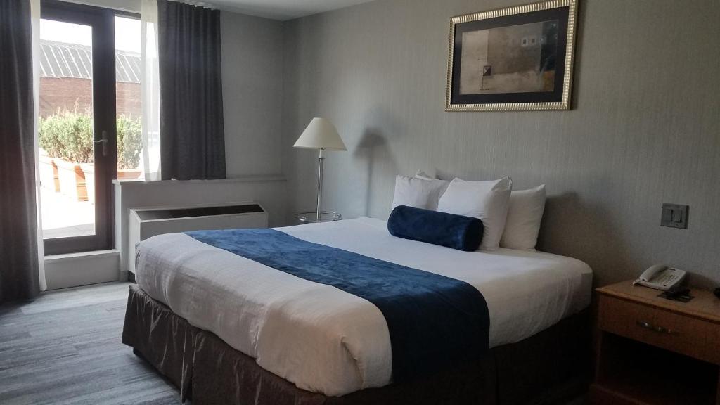 um quarto de hotel com uma cama grande e uma janela em Marco LaGuardia Hotel & Suites em Queens