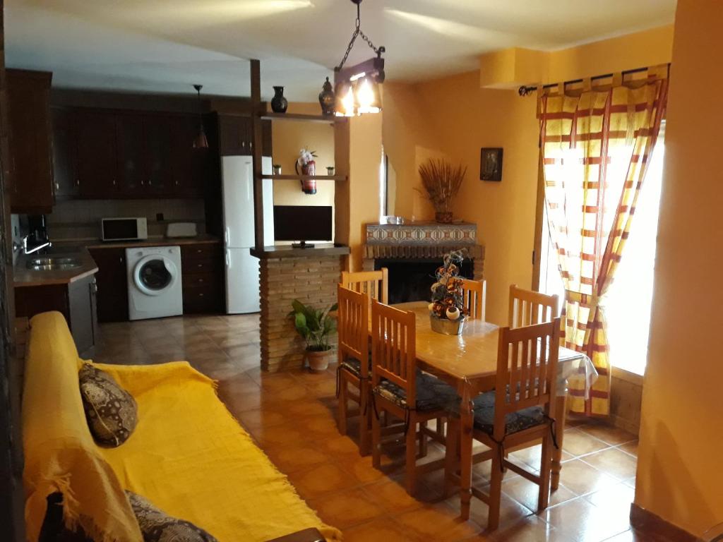 eine Küche und ein Wohnzimmer mit einem Tisch und Stühlen in der Unterkunft Alojamiento rural Esparteria in Cazorla
