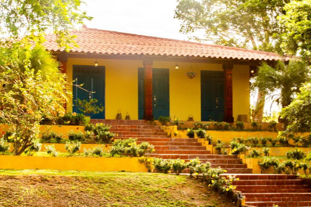 a yellow house with stairs in front of it at Finca Pamel in Los Santos