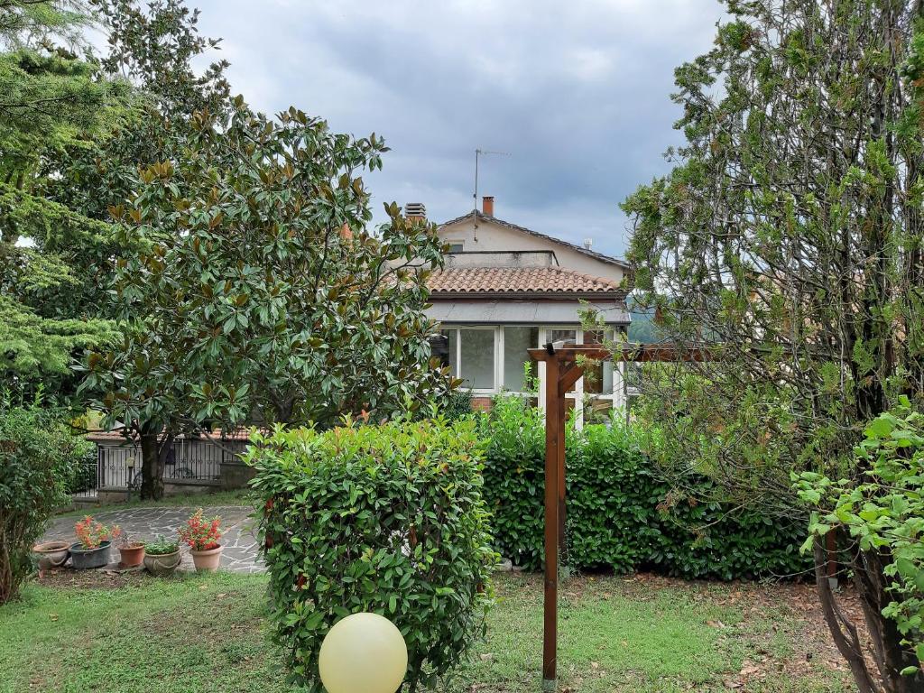 ein Haus mit einem Garten mit Bäumen und einem Zaun in der Unterkunft casa vacanze Rita in Gubbio