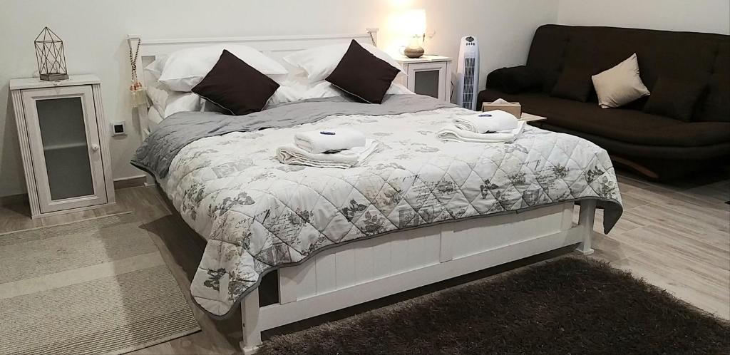 um quarto com uma cama com um cobertor e um sofá em Villa Košice em Košice