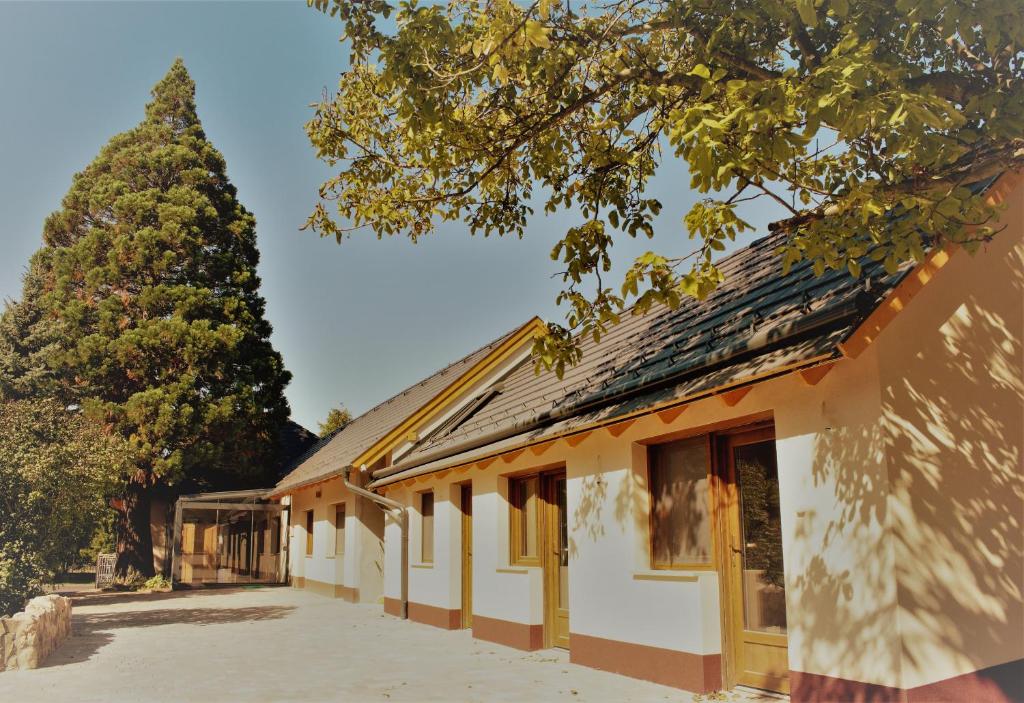 a building with a tree in front of it at Mamutfenyő Panzió in Tata