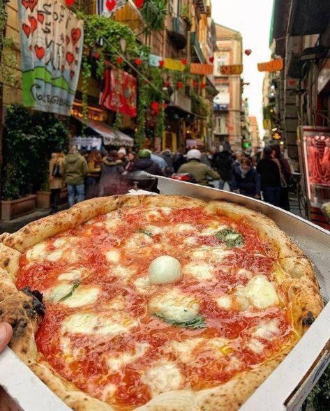 osoba trzymająca pizzę w pudełku w obiekcie casa piano zero w mieście Neapol