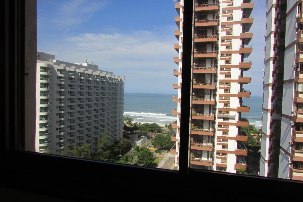 una vista sull'oceano dalla finestra di un edificio di Apto de 2 quartos e 2 banheiros sociais no Barramares a Rio de Janeiro