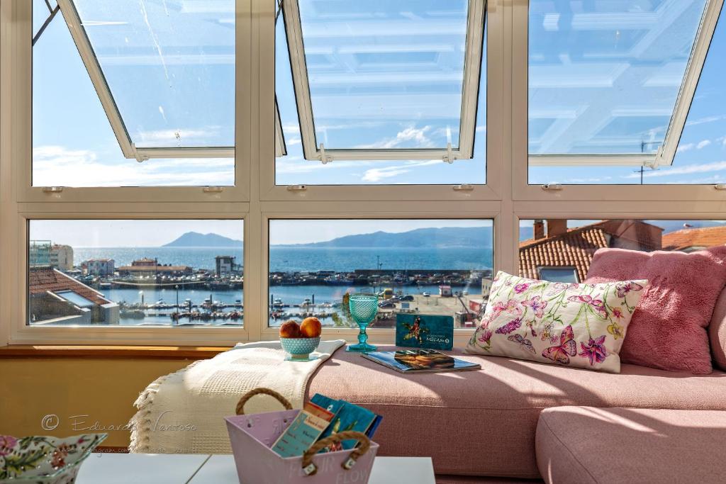 - un salon avec un canapé et une grande fenêtre dans l'établissement Noia Compostellae Beach, à Portosín