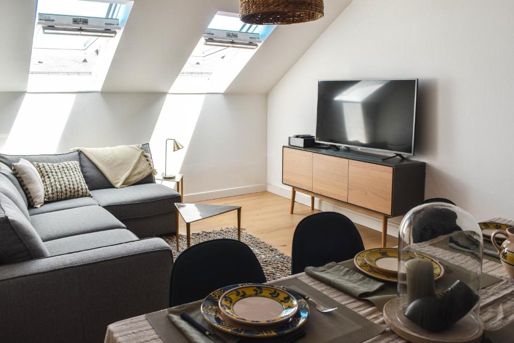 un salon avec un canapé et une télévision dans l'établissement Charme en centre ville, tout équipé, local vélos, à Angers