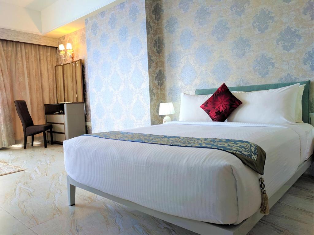 1 dormitorio con 1 cama blanca grande con almohadas rojas en Robinsons Apartments at Times Square KL en Kuala Lumpur