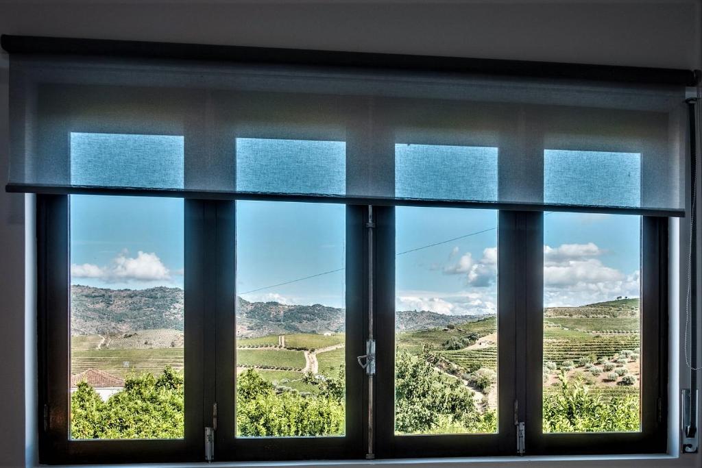 ein Fenster mit Blick auf die umliegende Landschaft in der Unterkunft BABhouse Casa da Colmeia - Coração do Douro in São João da Pesqueira