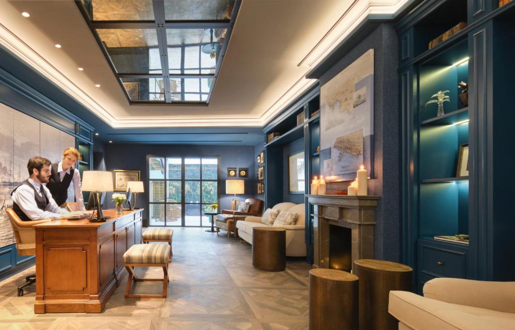 a hotel lobby with a man and a woman at a desk at Hotel Antigua Palma - Casa Noble in Palma de Mallorca