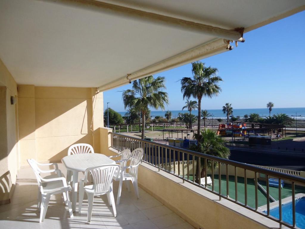 balcón con mesa, sillas y vistas al océano en Apartamentos Alboran 4/6 LEK, en Peñíscola