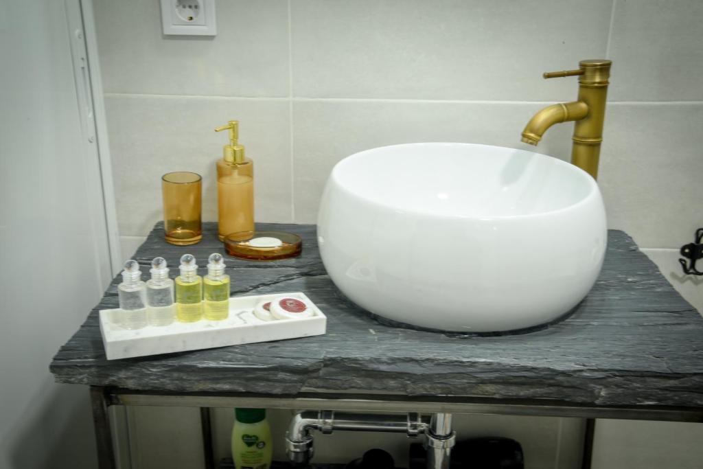 a bathroom counter with a bowl sink and bottles of soap at W3Inn LA LATINA (Cava Baja 30) in Madrid