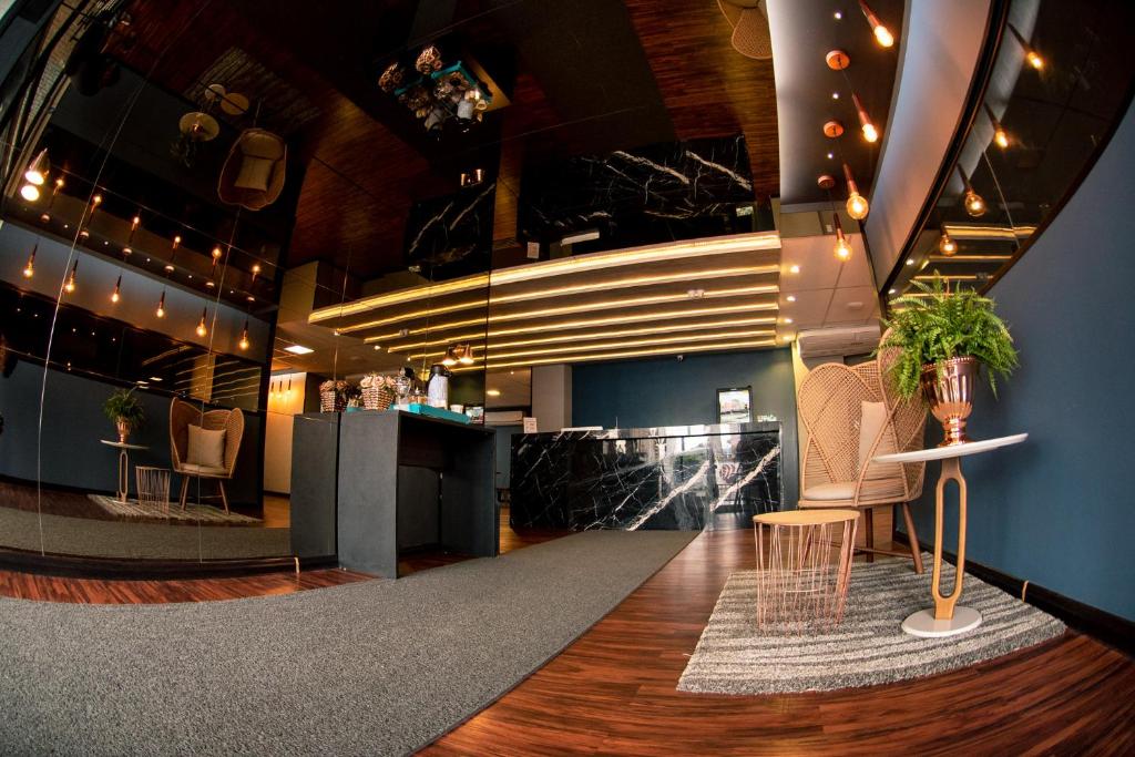 a lobby with a bar with chairs and a table at Jockey Class Hotel in Teresina