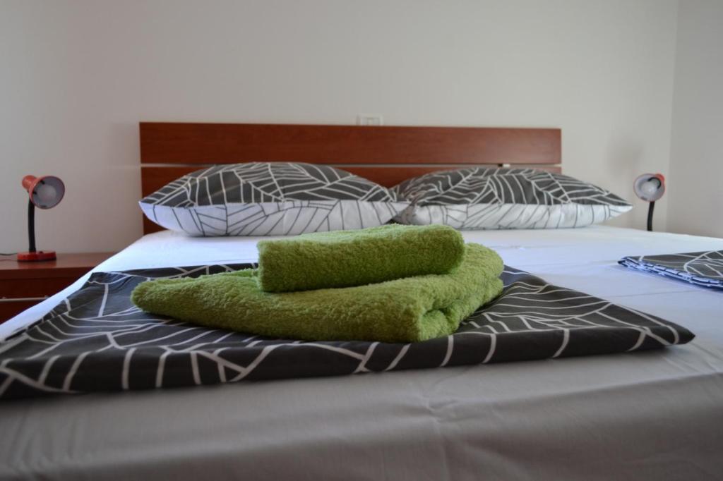 łóżko z zielonym ręcznikiem na górze w obiekcie Apartment Din w mieście Banjole