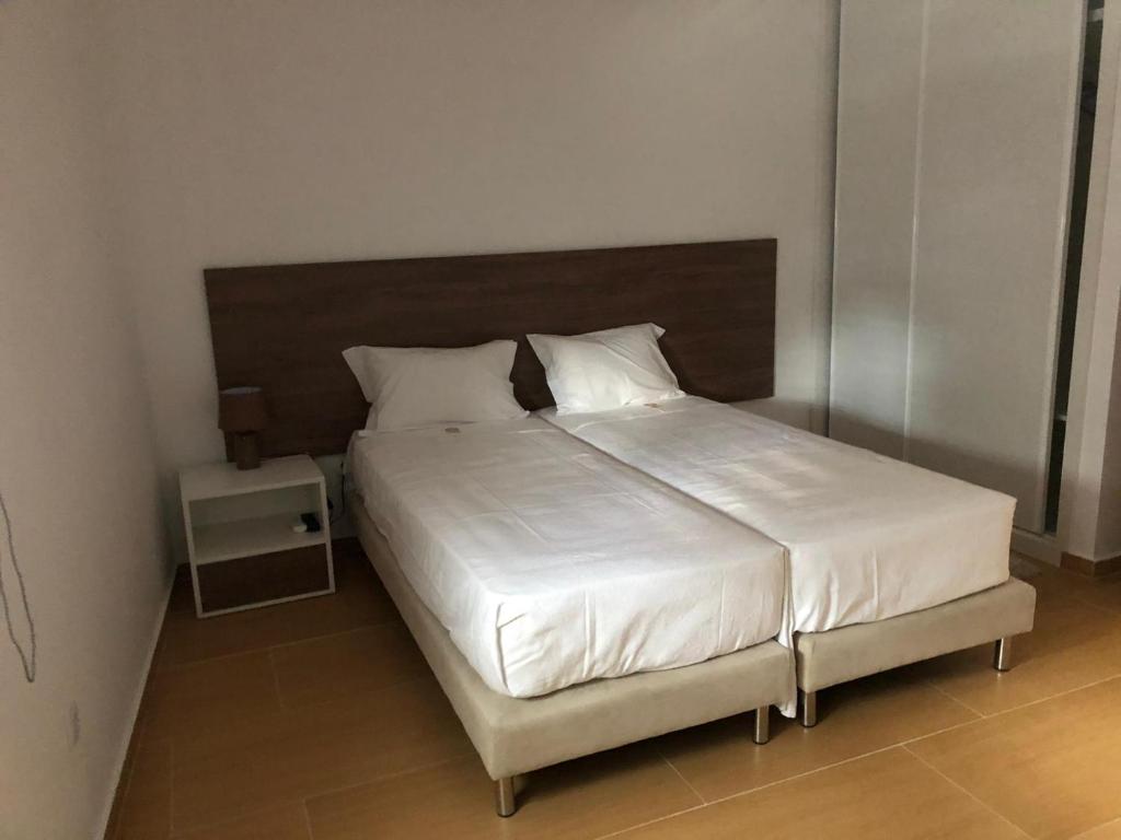1 dormitorio con 1 cama grande con sábanas y almohadas blancas en Marqueses de Ferreira, en Lamas de Ferreira