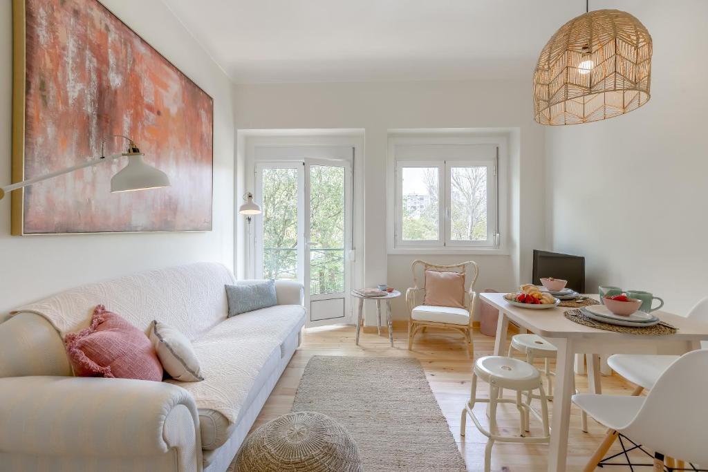 a living room with a white couch and a table at Sunny, Bright and Quiet Apartment, By TimeCooler in Lisbon