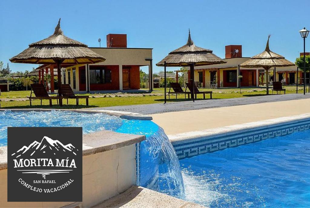 a resort with a swimming pool and umbrellas at Cabañas Morita Mia in San Rafael