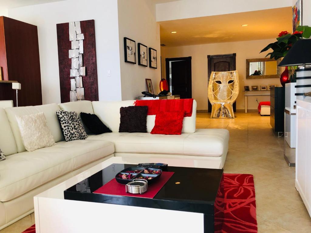 een woonkamer met een witte bank en een tafel bij 5* Stunning Views - Savana at Porto Cupecoy St Maarten in Lowlands