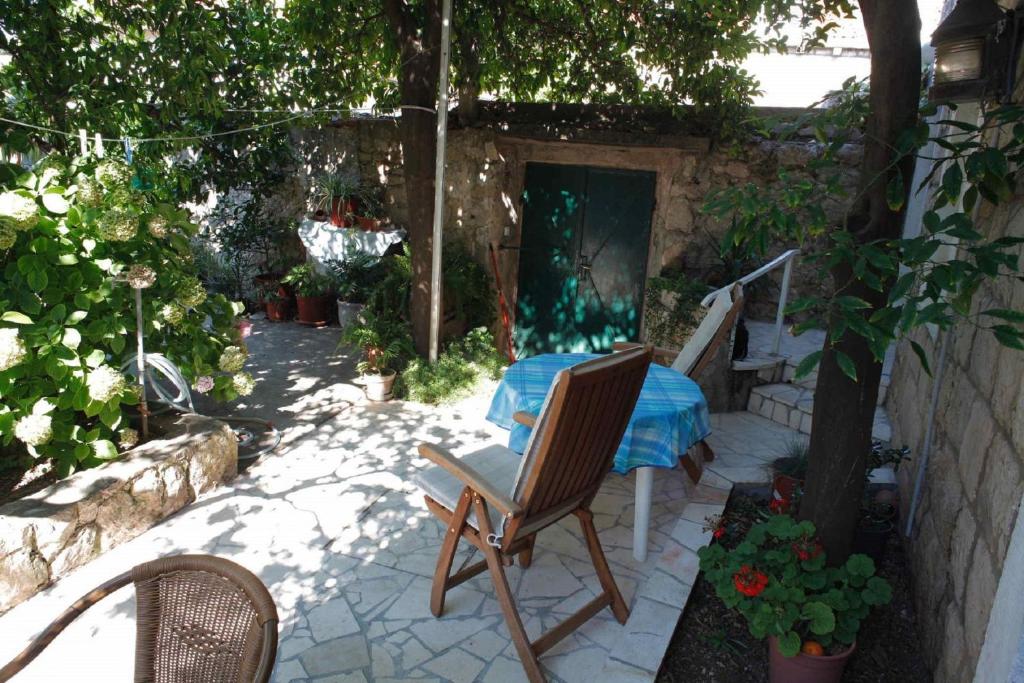 a patio with a table and chairs in a garden at Apartment Milu - 80m from sea in Cavtat