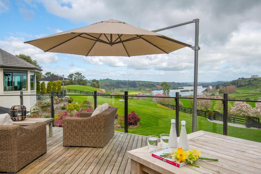 a patio with an umbrella and a table and chairs at Lakeview Lodge Karapiro in Cambridge