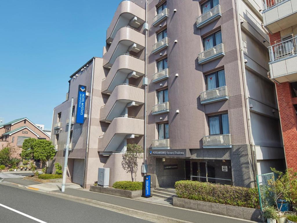 a tall apartment building on a city street at HOTEL MYSTAYS Kiyosumi Shirakawa in Tokyo