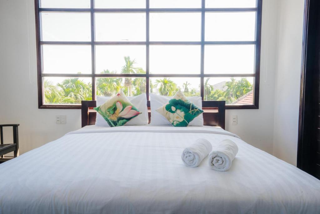 Postel nebo postele na pokoji v ubytování Hoi An Lotus Aroma Villa
