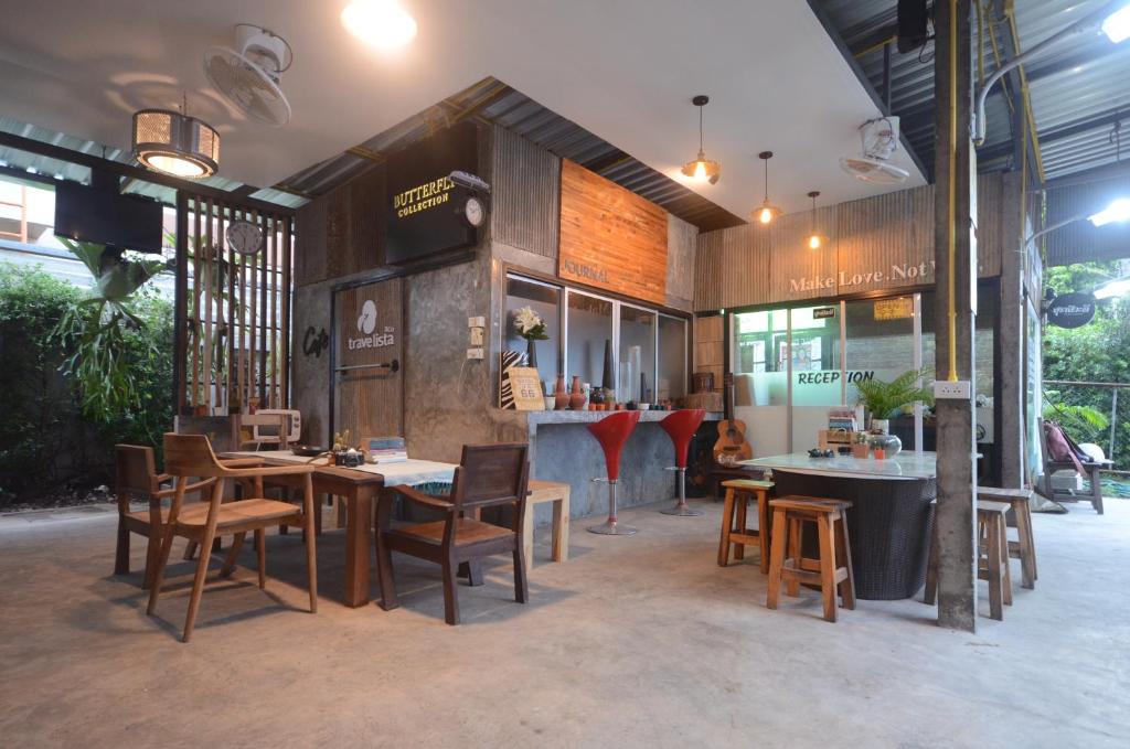 a restaurant with wooden tables and chairs and a counter at Suandok History House in Chiang Mai