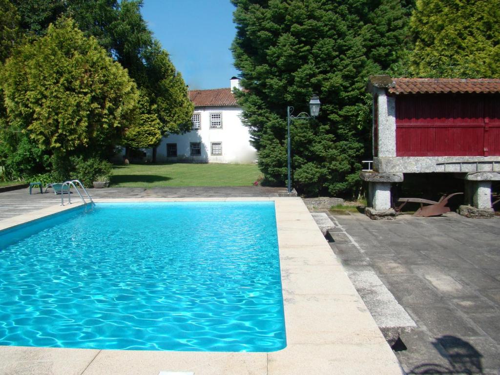 a large blue swimming pool next to a house at Casa das Paredes in Fafe
