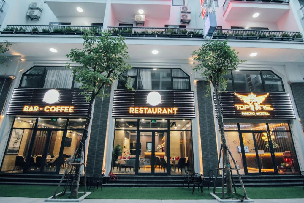 un ristorante con due alberi di fronte a un edificio di Topone Halong Hotel a Ha Long