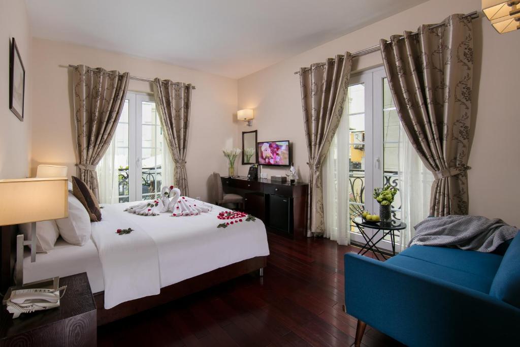 1 dormitorio con 1 cama blanca y 1 sofá azul en Sunline Hotel, en Hanói