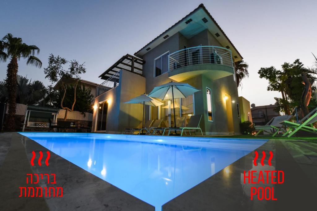 uma casa com piscina em frente a uma casa em Villa Or - Heated Pool em Eilat