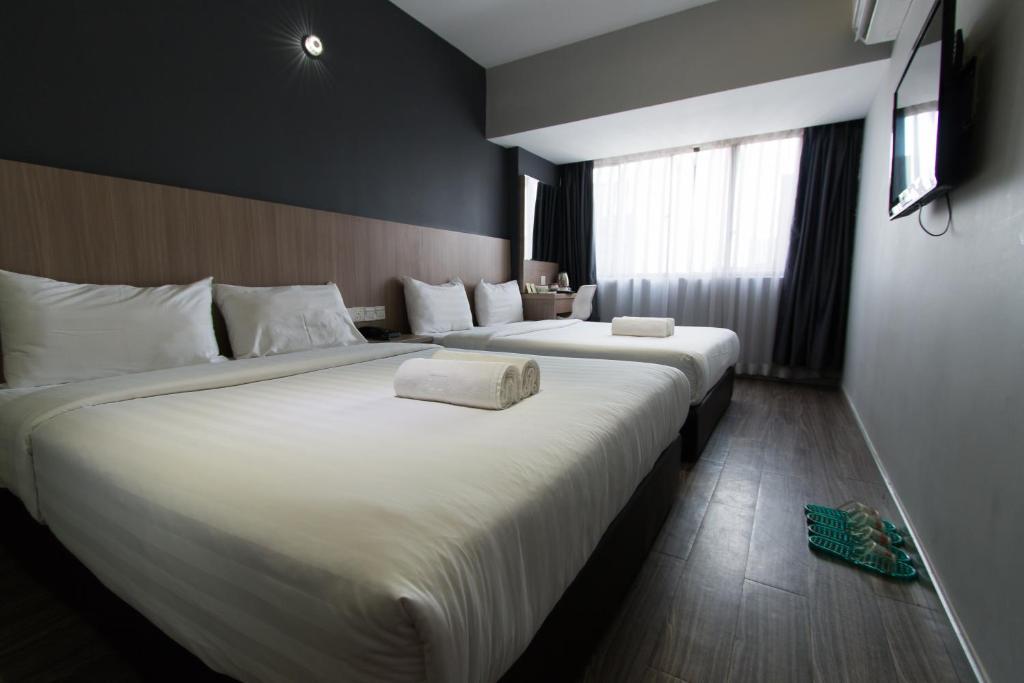 two beds in a hotel room with white sheets at Hotel 99 SS2 Petaling Jaya in Petaling Jaya