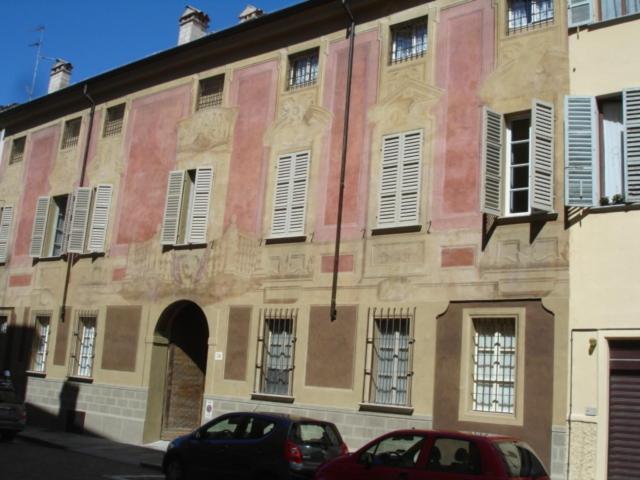 un edificio con un coche rojo estacionado frente a él en Holiday House La Colombaia, en Parma