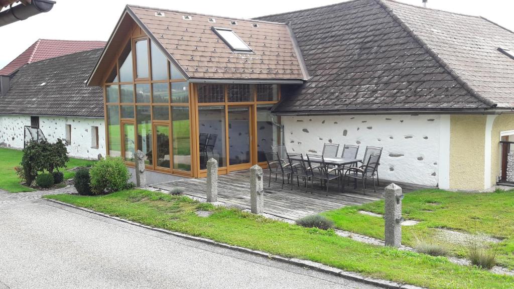 Casa con terraza con mesa y sillas en Ferienwohnung Haiberg en Rudolfing