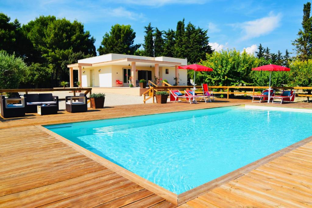 ein Schwimmbad mit einem Haus im Hintergrund in der Unterkunft B&B Villa Jonica in Gallipoli
