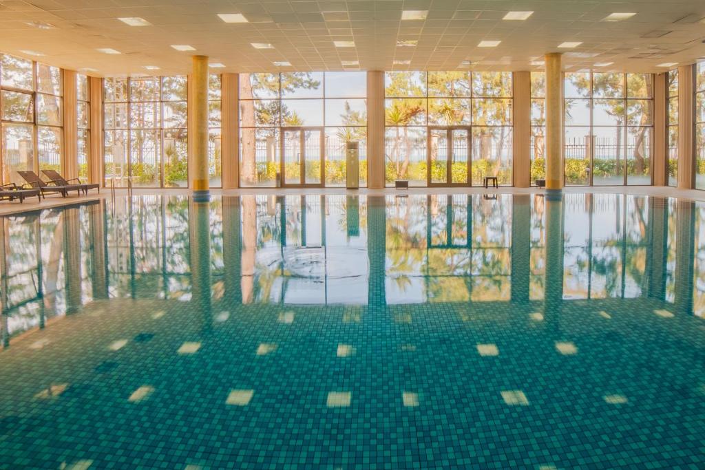 an empty swimming pool with a reflection in the water at Kobuleti Georgia Palace Hotel & Spa in Kobuleti