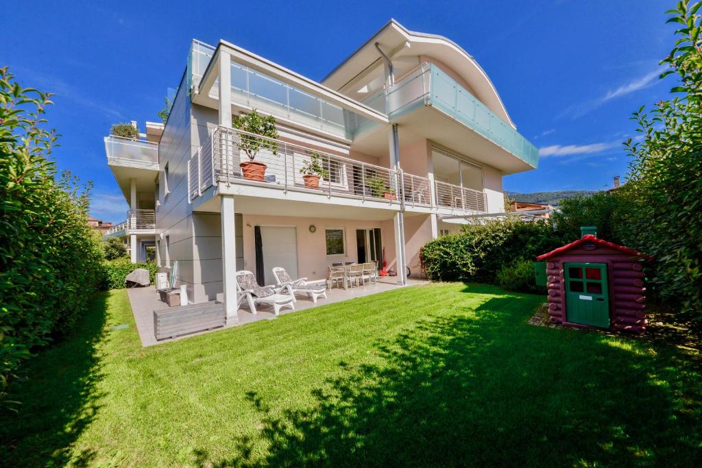a large white house with a yard at 1Dest - Private Garden In Paradise in Riva del Garda