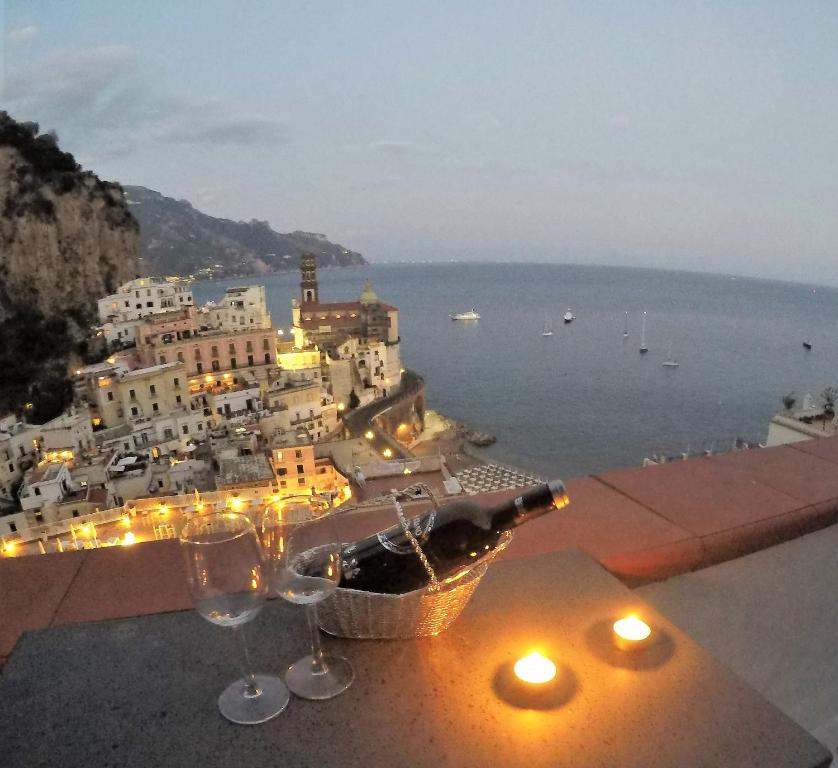 a view of a town with wine glasses on a ledge at Villa La Mura in Atrani