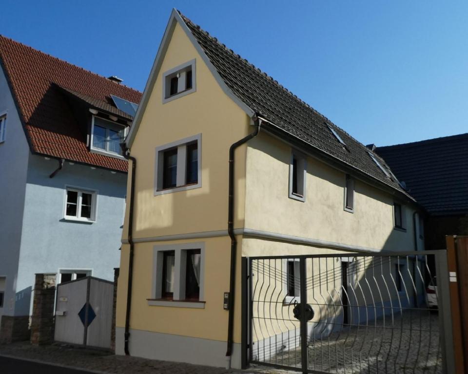 una casa amarilla junto a un edificio blanco en IFAM - Ihr Ferienhaus am Main, en Zellingen