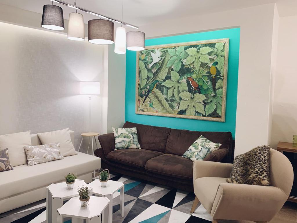 - un salon avec un canapé, des chaises et un tableau dans l'établissement Apartamento Plaza del Pilar, à Saragosse