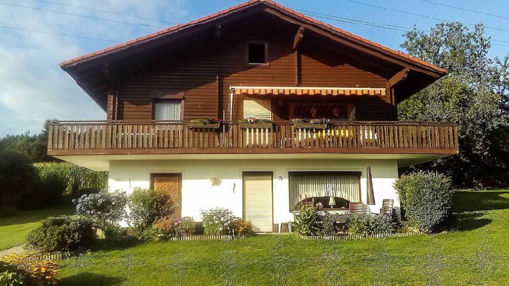 Casa de madera grande con balcón en la parte superior. en Ferienwohnung Rihm, en Arrach