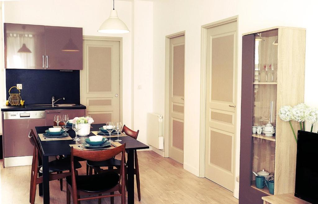 une cuisine avec une table et des chaises dans une pièce dans l'établissement S'House - Centre of Beaune, à Beaune