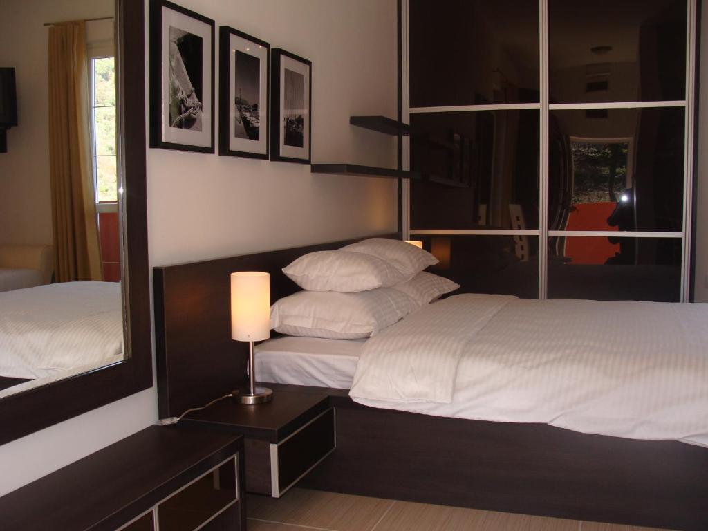 a bedroom with two beds and a lamp and a mirror at Apartments Danilo Kažanegra in Sveti Stefan