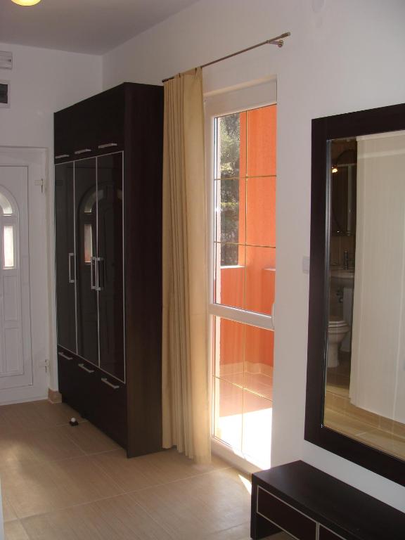 a living room with a large window and a black cabinet at Apartments Danilo Kažanegra in Sveti Stefan